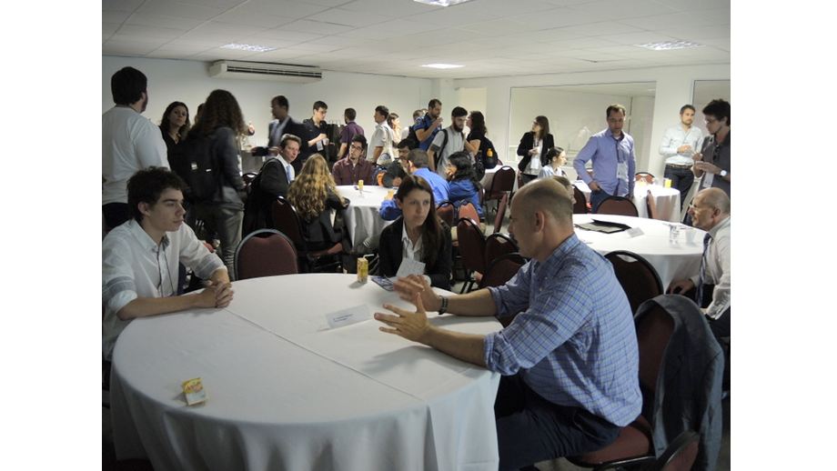The audience spread out and sat down at various tables. In the foreground: Professor Marbach chatting with attendees
