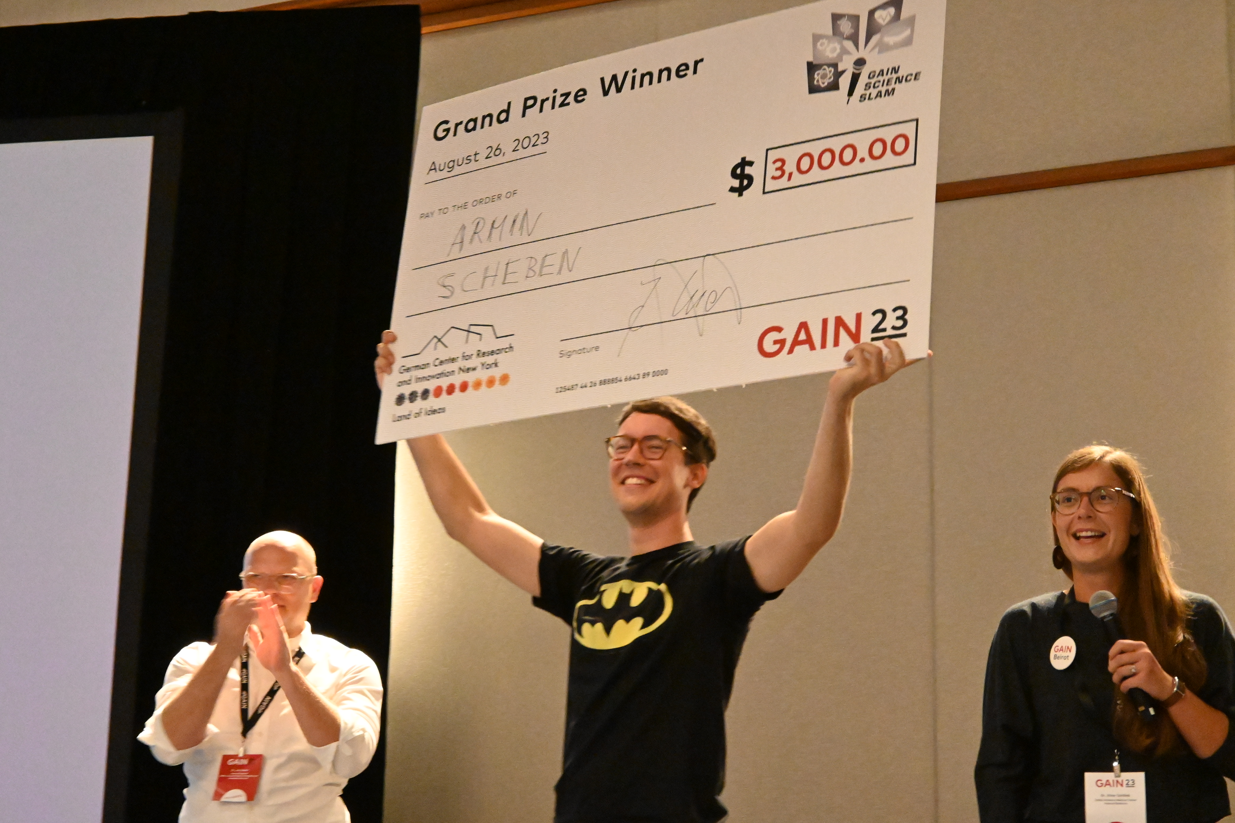 Große Freude beim Gewinner des diesjährigen Science Slams: Armin Scheben präsentiert den Scheck für das Preisgeld von 3000 Dollar.