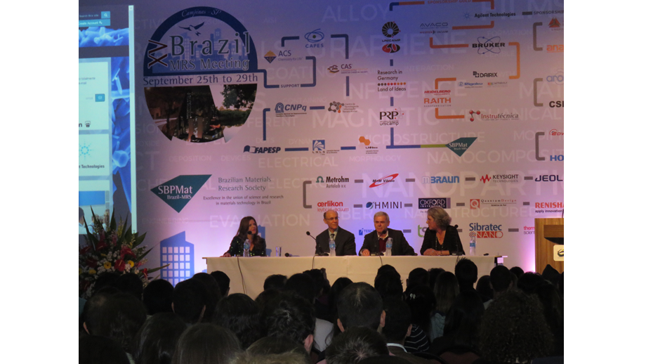 A imagem mostra os quatro panelistas sobre o palco. Ao fundo está um painel com o logo do congresso.