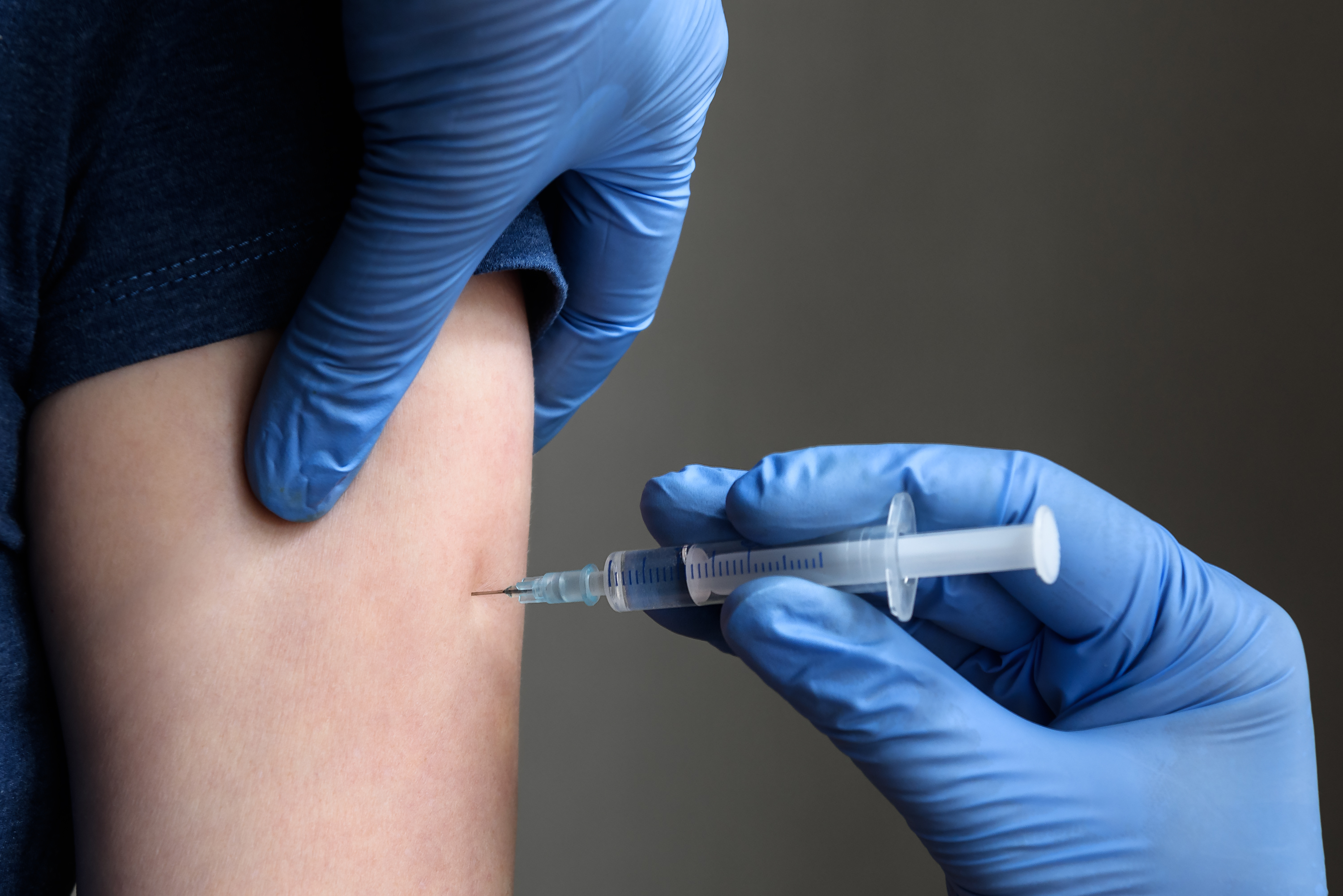 Impfsituation: Eine Spritze im Oberarm einer Person