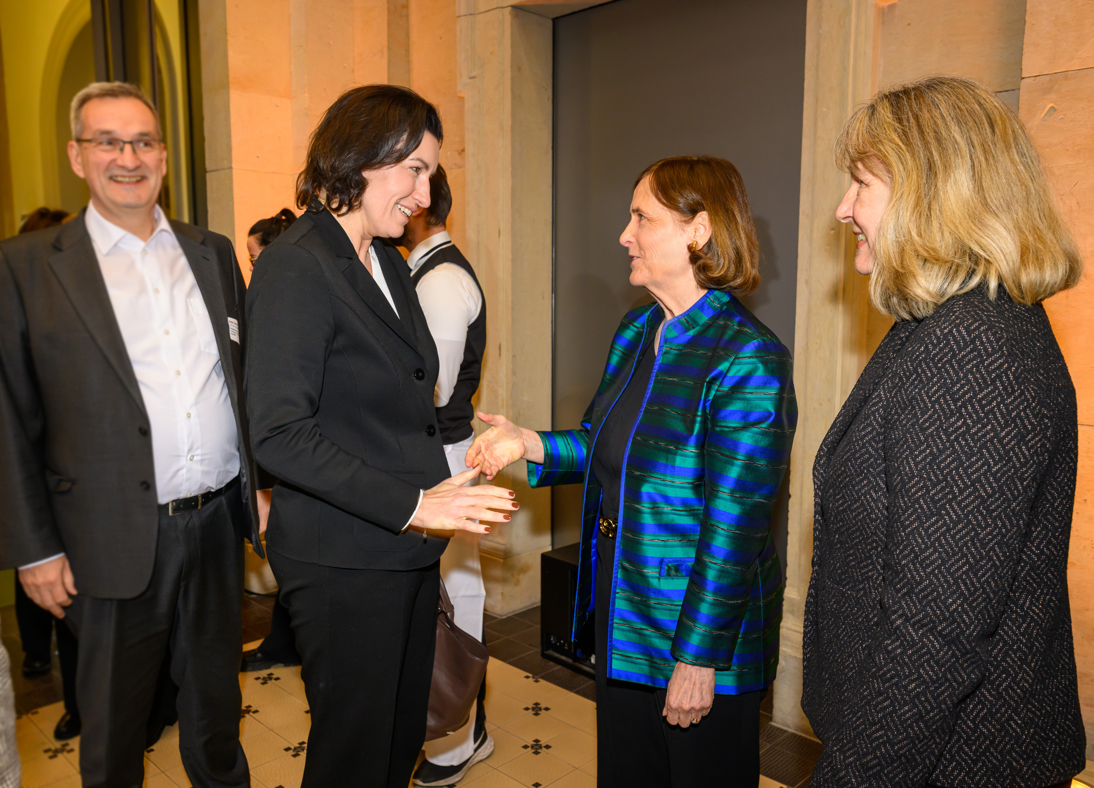 Der DFG-Vorstand begrüßt Bundesministerin Bär: Katja Becker und die Ministerin geben sich die Hand, daneben steht Heide Ahrens