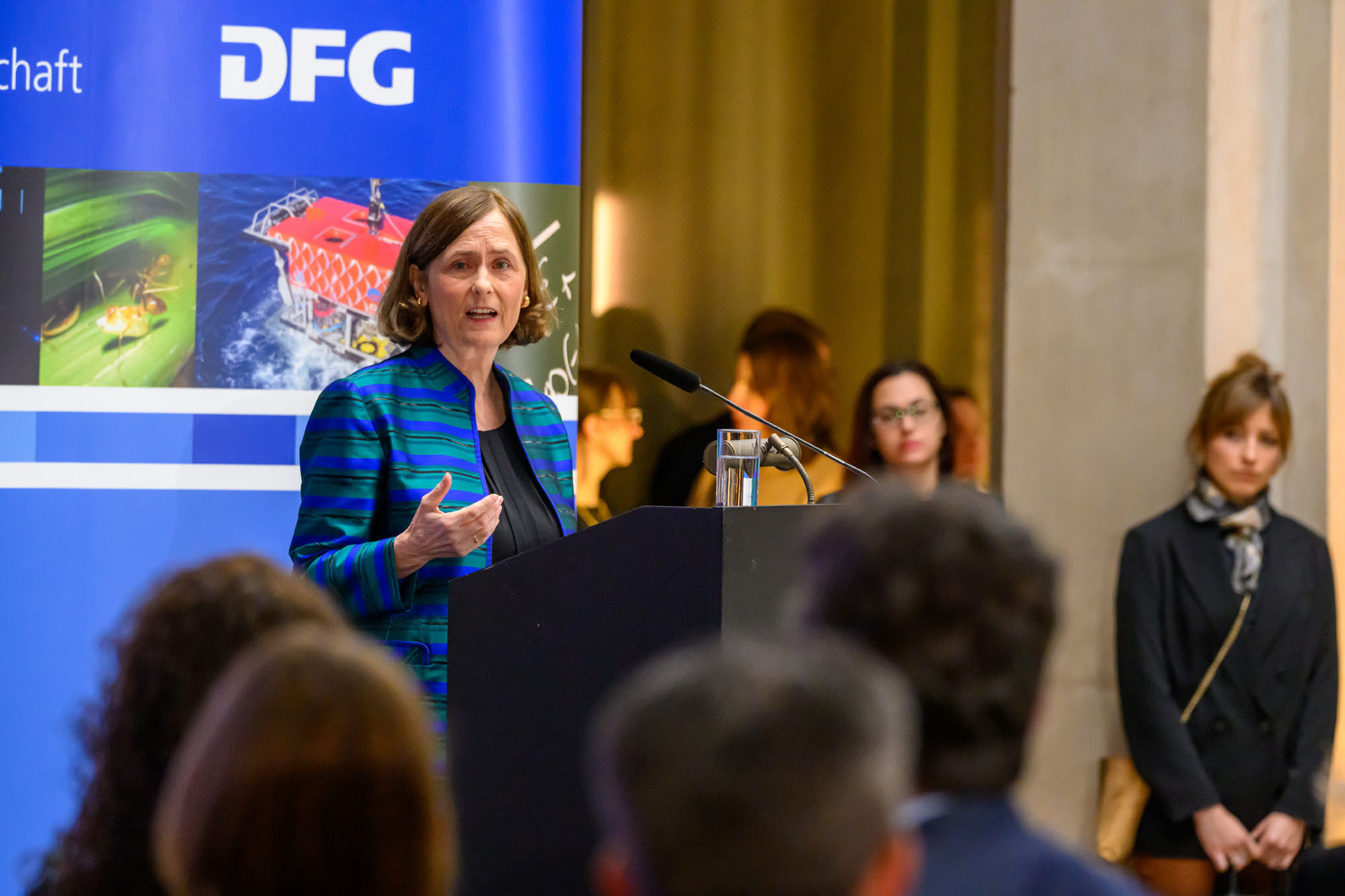 DFG-Präsidentin Katja Becker steht vor einem Pult und hält eine Rede