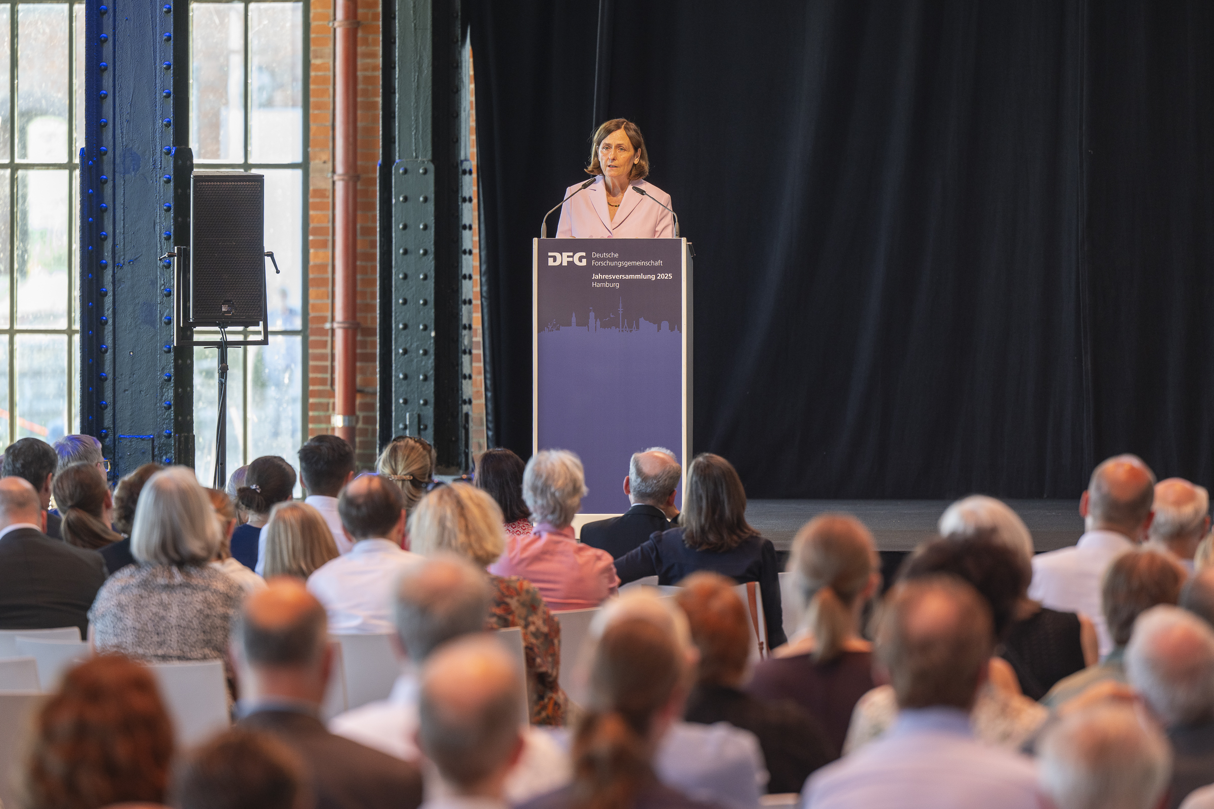 DFG-Präsidentin Katja Becker steht vor einem Pult und hält eine Rede