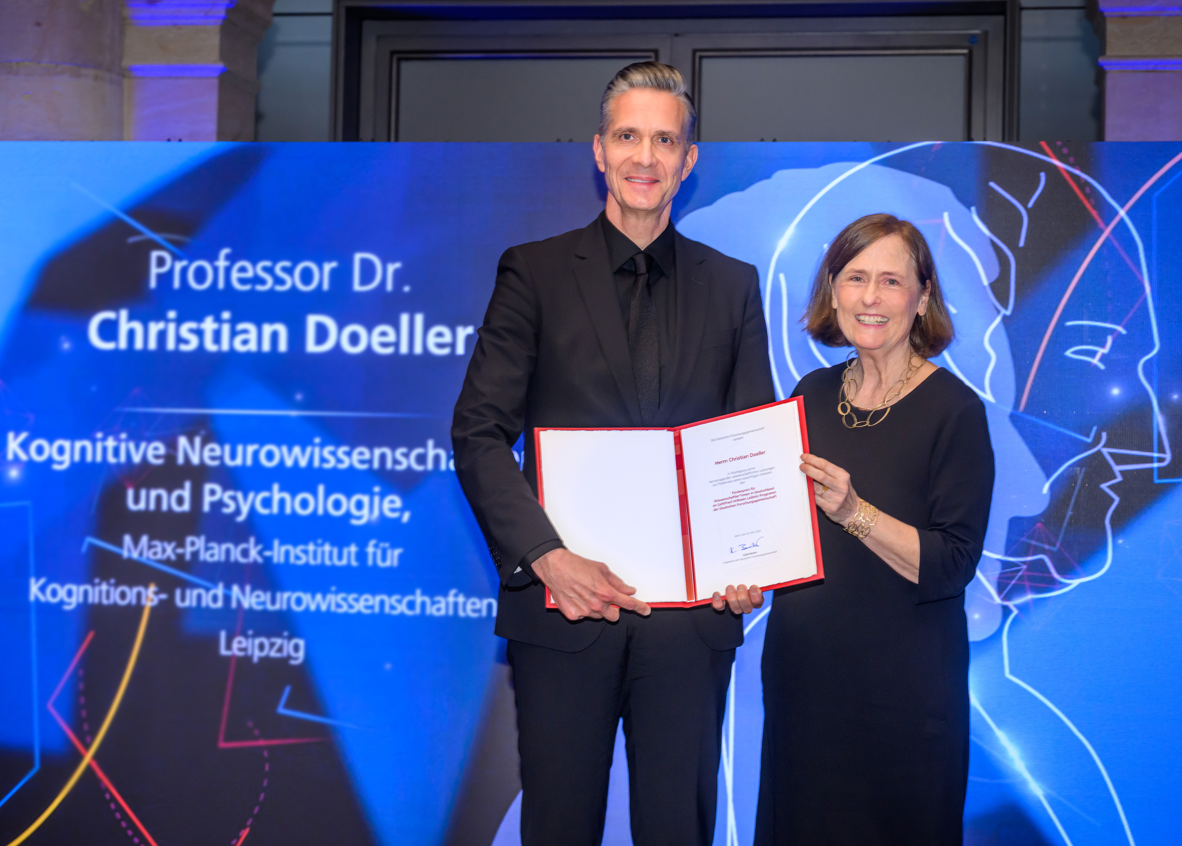 Preisverleihung an Prof. Dr. Christian Doeller - zu sehen mit DFG-Präsidentin Prof. Dr. Katja Becker