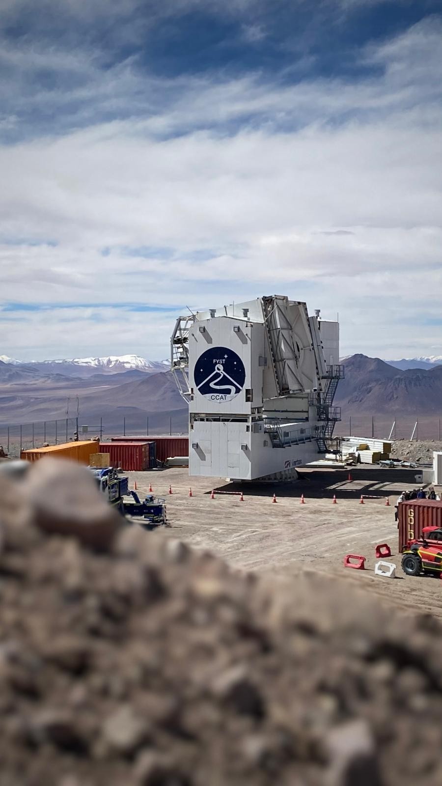 The Fred Young Submillimeter Telescope is located on a plateau surrounded by mountains.