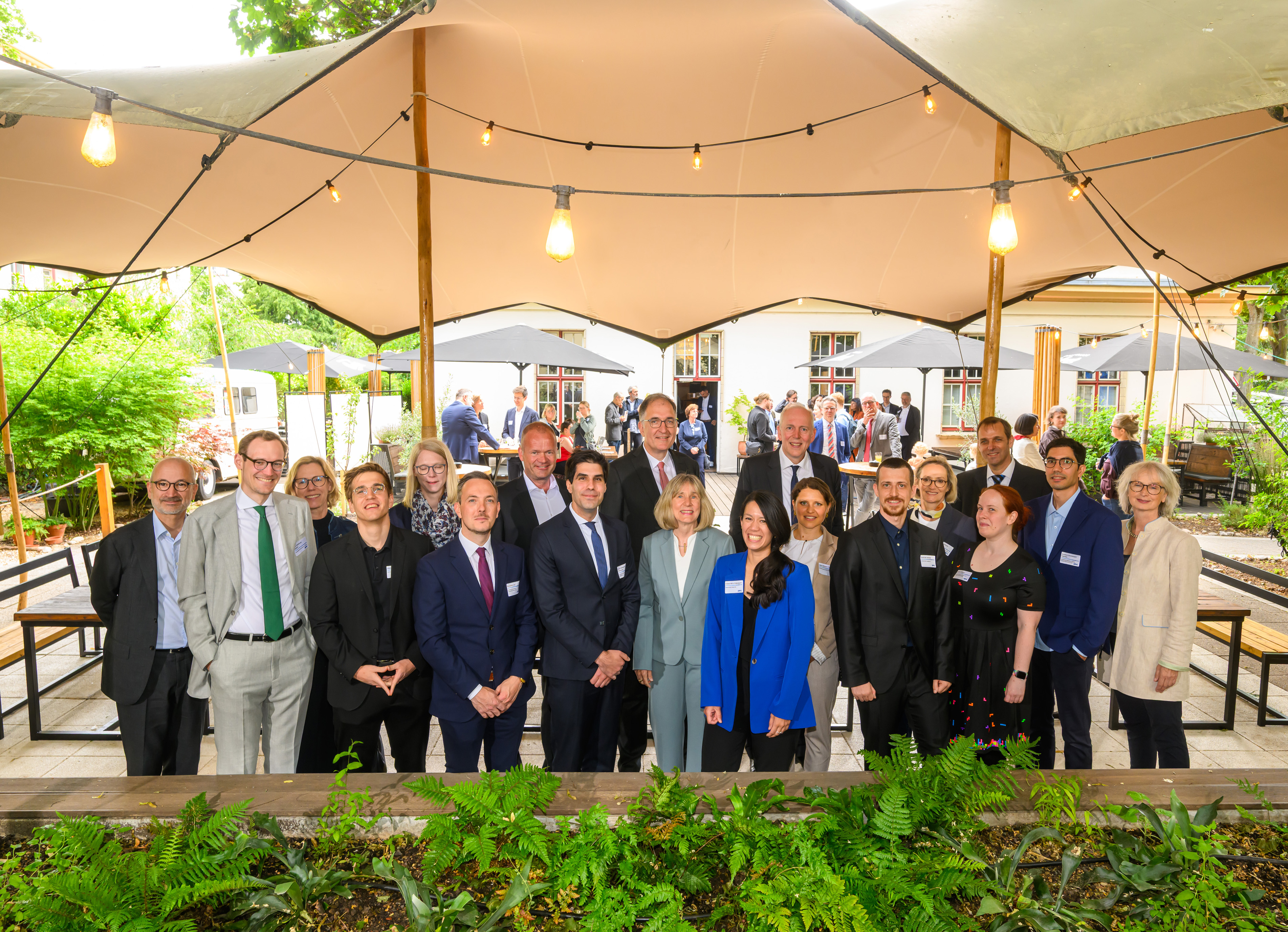 Gruppenbild: Die Preisträger*innen, die Mitglieder des Auswahlausschusses sowie der DFG-Generalsekretärin Dr. Heide Ahrens und Jakob von Weizsäcker, Minister für Finanzen und Wissenschaft des Saarlandes und Mitglied der Gemeinsamen Wissenschaftskonferenz stehen unter einem Zelt im Freien