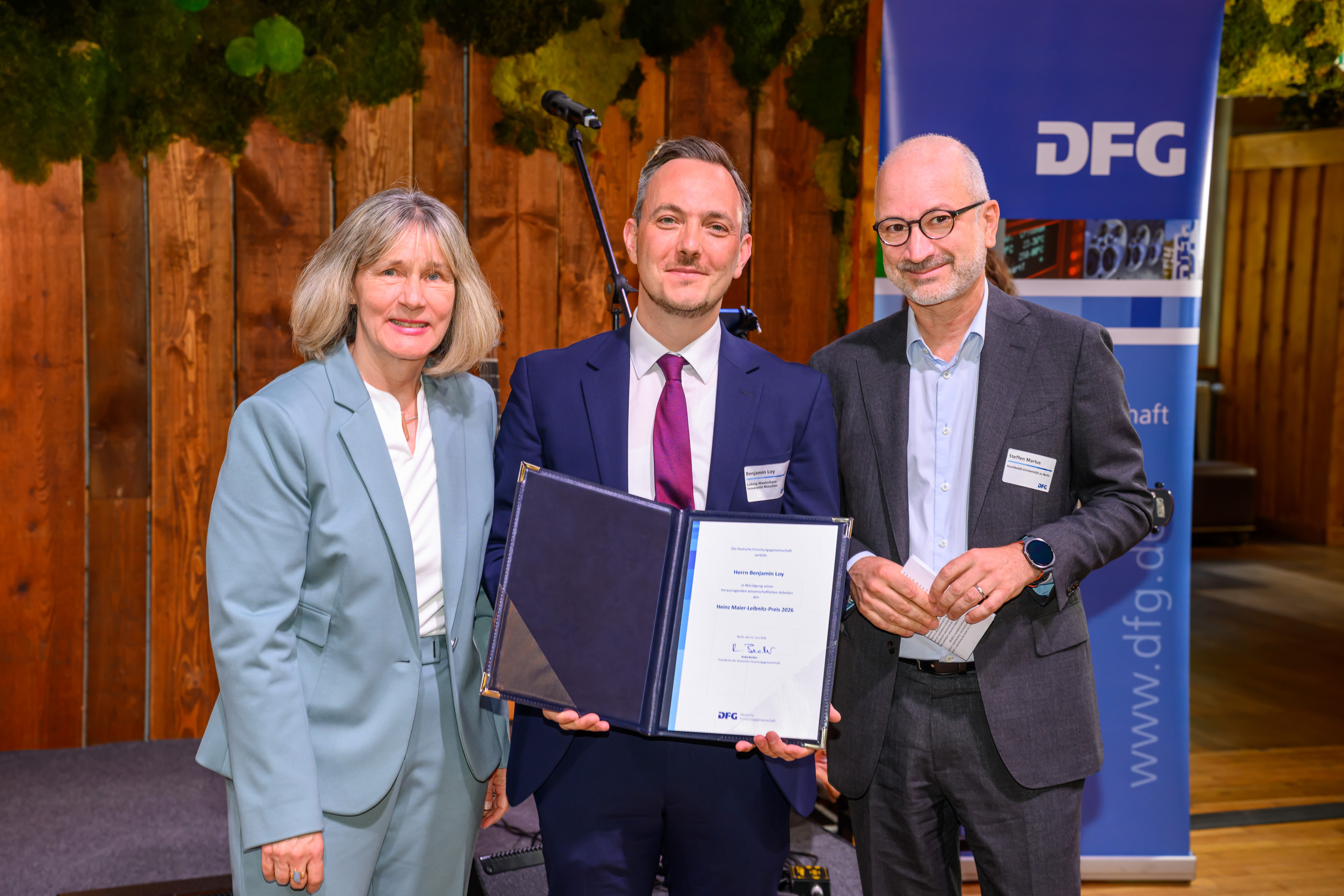 Preisverleihung an Prof. Dr. Benjamin Loy - mit DFG-Generalsekretärin Dr. Heide Ahrens und Prof. Dr. Steffen Martus (Mitglied des Auswahlausschusses)