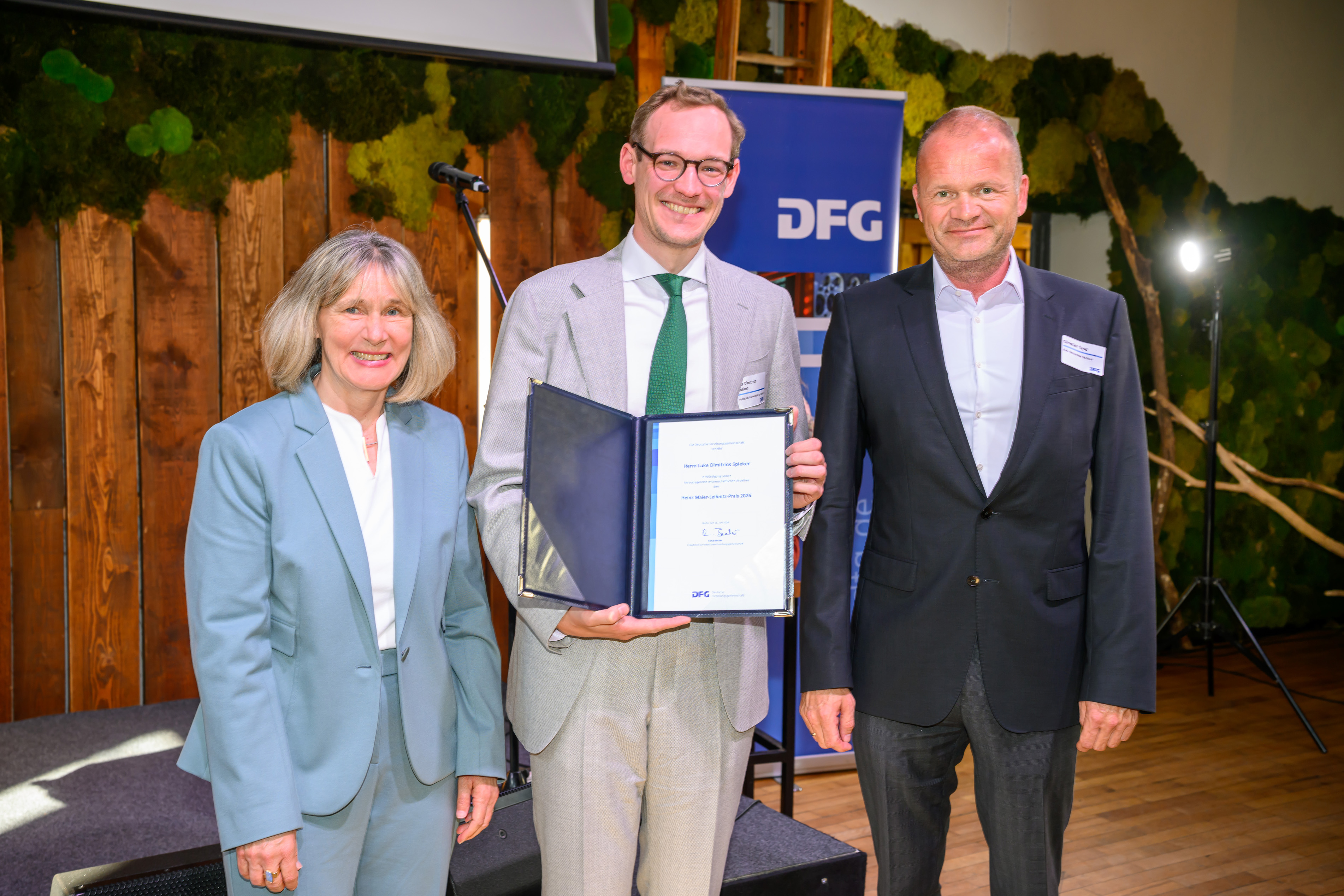 Preisverleihung an Dr. Luke Dimitrios Spieker - mit DFG-Generalsekretärin Dr. Heide Ahrens und Prof. Dr. Christian Tapp (Mitglied des Auswahlausschusses)