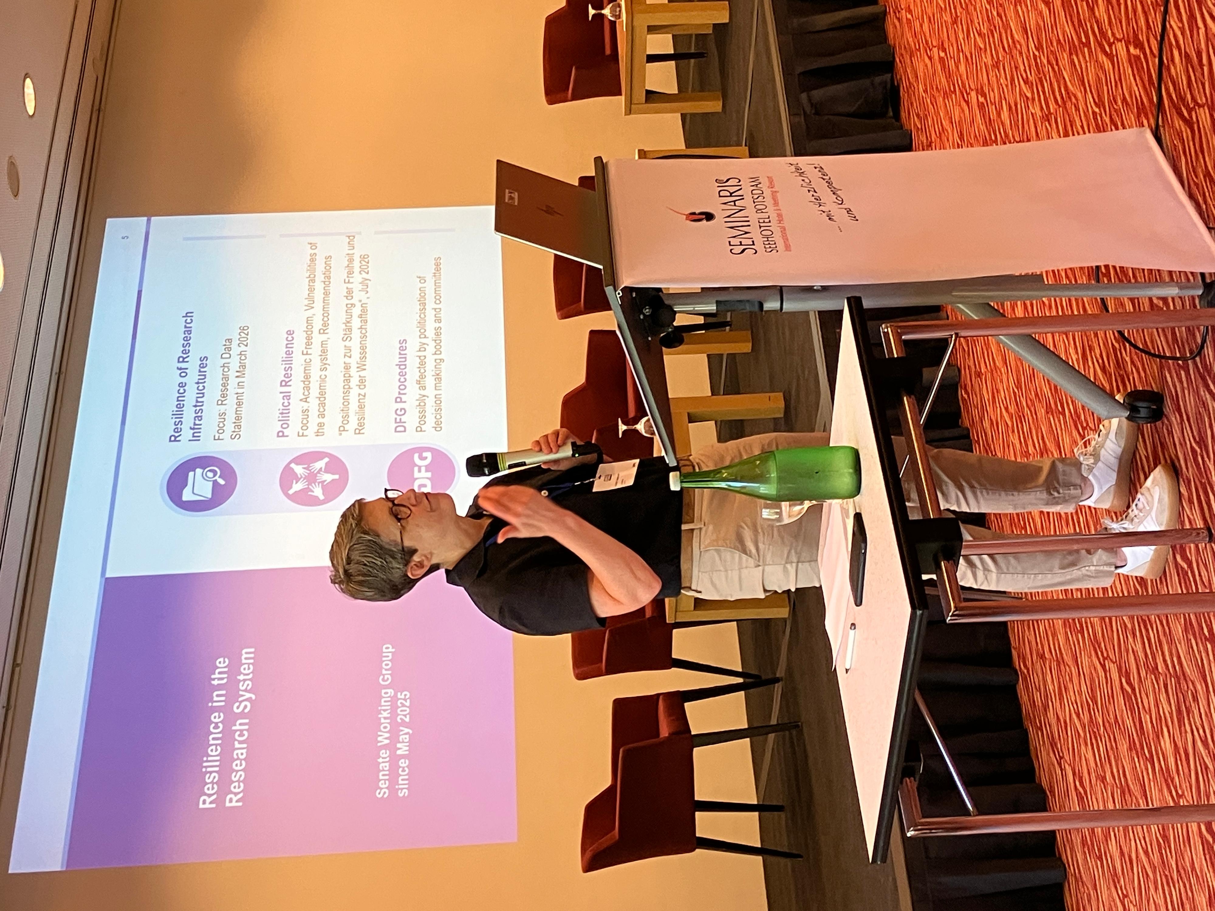 Prof. Britta Siegmund steht am Pult vor einer Präsentation und spricht