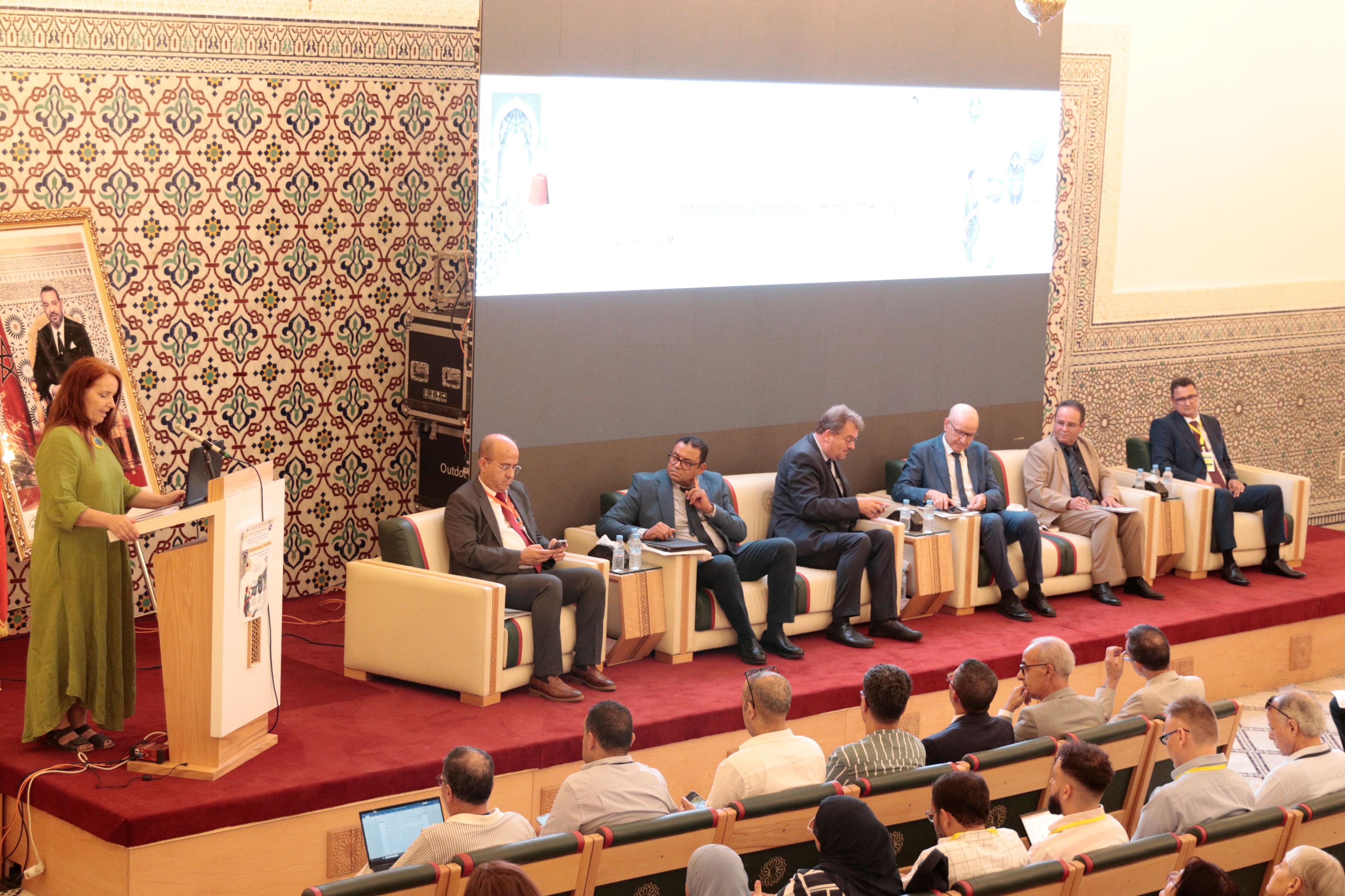 Participants are seated on stage while the speaker kicks off the event at the podium.