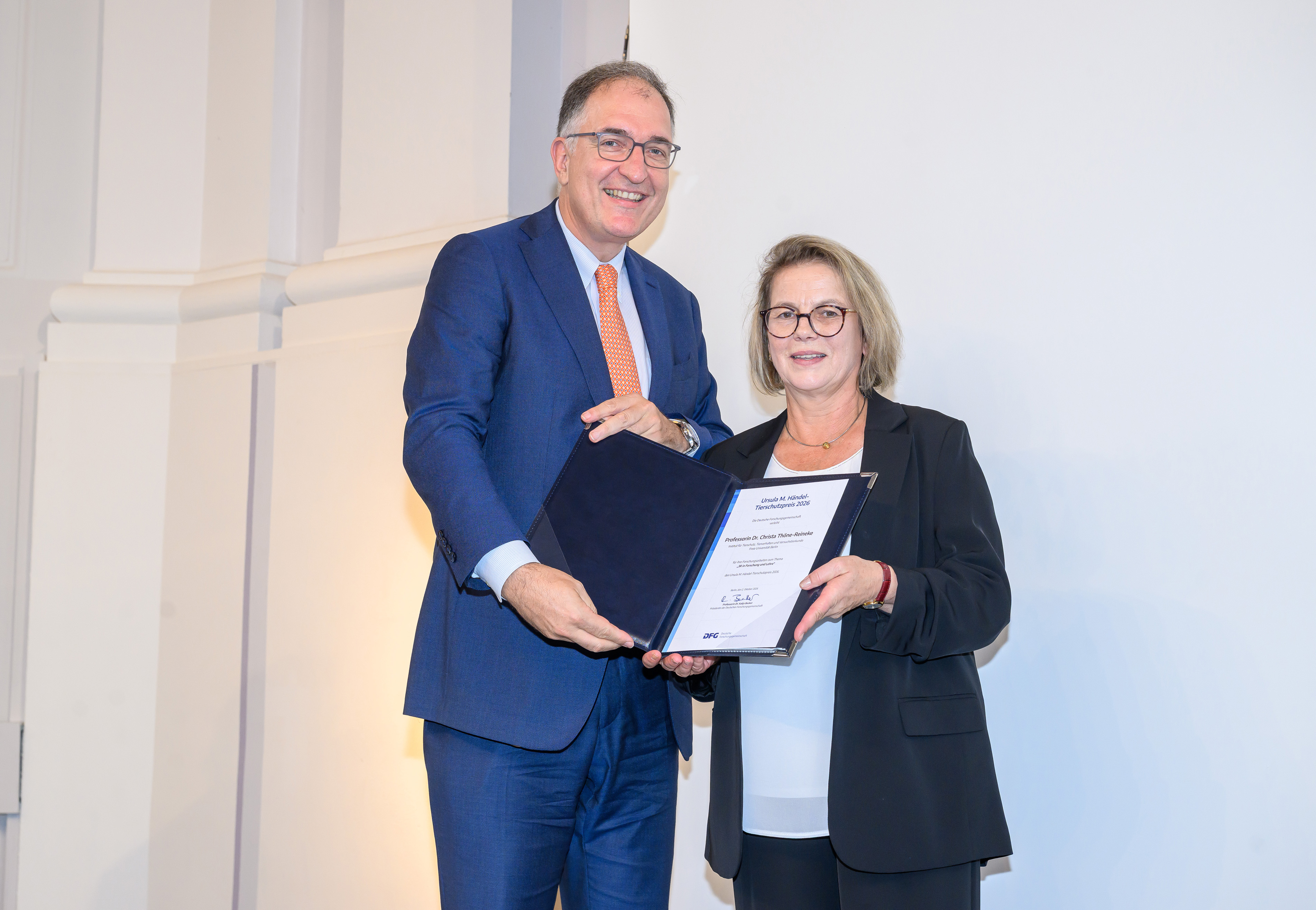Christa Thöne-Reineke mit DFG-Vizepräsident Peter Seeberger, beide halten die Urkunde in die Kamera