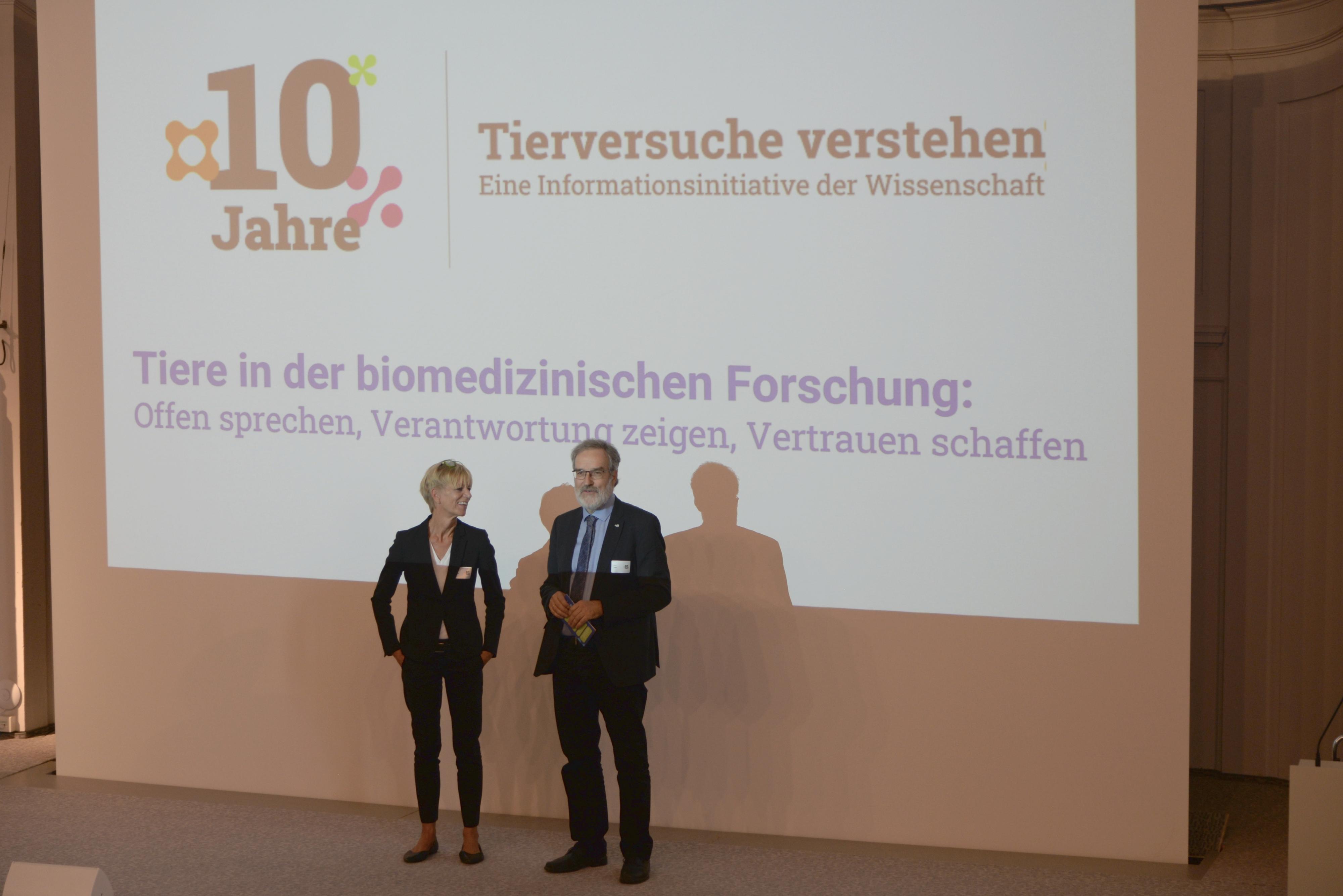 Brigitte Vollmar, Vorsitzende der DFG-Senatskommission für tierexperimentelle Forschung, und Stefan Treue, Sprecher von Tierversuche verstehen, stehen auf der Bühne