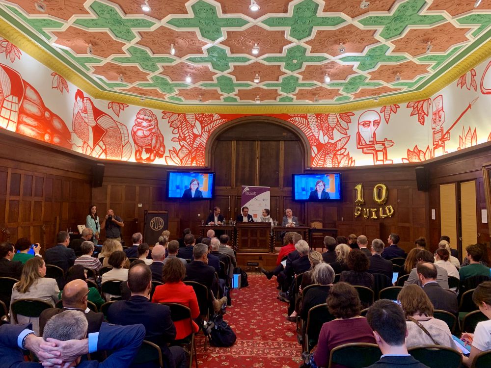 Ein Blick in den Saal mit Ballons, die "10" und "Guild" bilden, Katja Becker spricht auf Monitoren zur Festgesellschaft